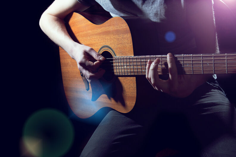 Musician playing on acoustic guitar